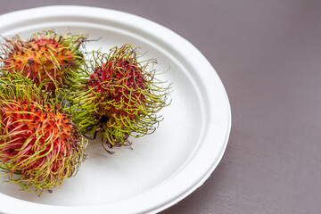 tropical rambutan fruit lies on a white plate close-up