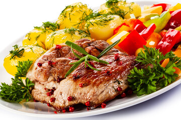 Grilled steak with boiled potatoes and vegetables on white background

