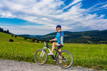 Young woman riding  bicycle on country road
