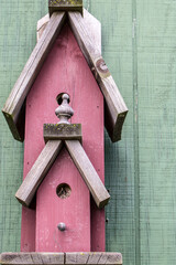 Rustic red barn wood birdhouse in vertical orientaion. 