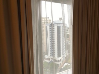 Glimpse of Bangkok city through hotel curtain window