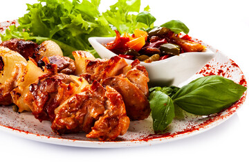 Grilled shashlik with vegetables on white background
