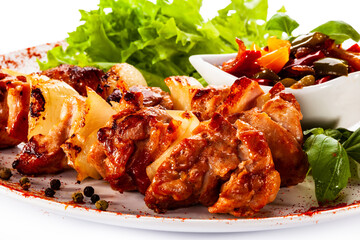 Grilled shashlik with vegetables on white background
