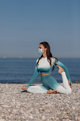young woman in mask practicing yoga outdoor