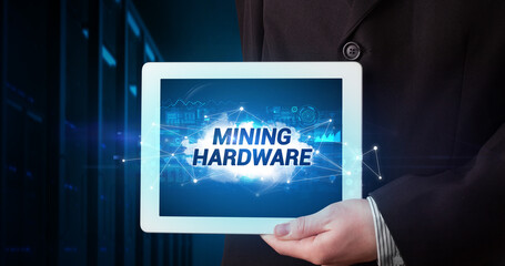 Young business person working on tablet and shows the inscription: MINING HARDWARE