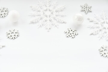 Fototapeta na wymiar Pattern made of white balls and snowflakes on white background.