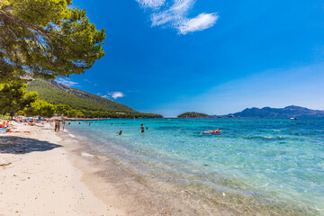Platja de Formentor, Mallorca, Spain - July 20, 2020: People enjoying popular beach in summer, Mallorca, Spain.