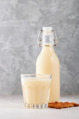 Vegan dairy free almond milk in bottle on gray background