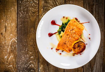 Fried salmon fillet with lemon served on wooden table 