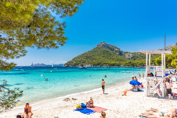 Fototapeta na wymiar Platja de Formentor, Mallorca, Spain - July 20, 2020: People enjoying popular beach in summer, Mallorca, Spain.