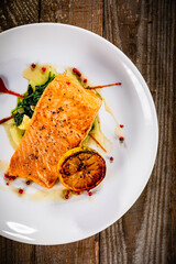 Fried salmon fillet with lemon served on wooden table 