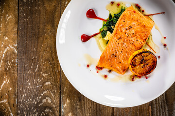 Fried salmon fillet with lemon served on wooden table 