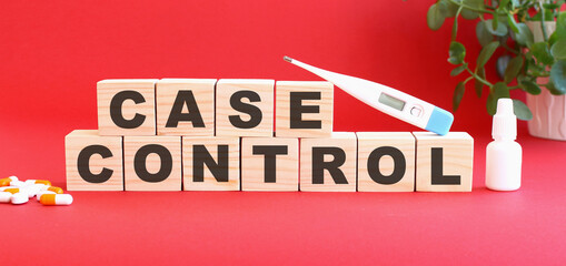 The words CASE CONTROL is made of wooden cubes on a red background with medical drugs. Medical concept.