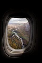 Airplane interior with window view of the highlands of Iceland