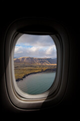 Airplane interior with window view of the coast in Iceland