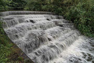 White Water flowing over weir low-level view at long exposure go give blurred motion effects