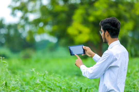 Technology and people concept, Young indian agronomist with tablet at field