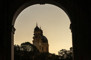 Munich theatiner church during sunset, framed by arch