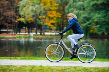 Urban biking - woman riding bicycle in city park
