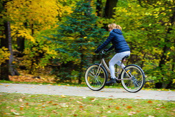 Fototapeta premium Urban biking - woman riding bicycle in city park 