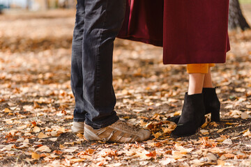 men's and women's feet stand on yellow autumn foliage