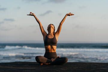 young beautiful woman meditation on beach. Bali Indonesia.