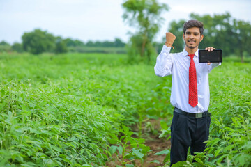 Technology and people concept, Young indian agronomist showing tablet at field