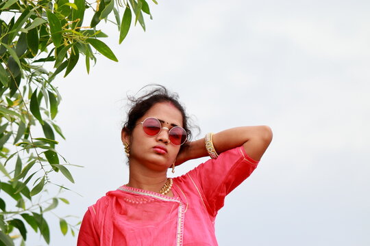 adult female model posing in a beautiful traditional dress and wearing new style sunglasses above the eyes,