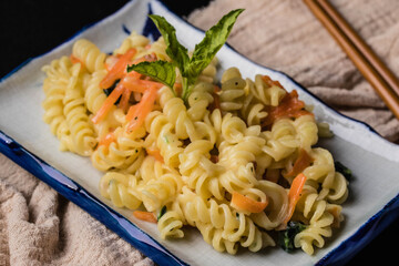 Macaroni Carbonara with Carrot. Dark tone.