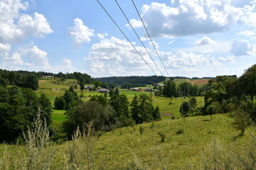 View from the top of a tall hill showing a number of vast fields, meadows, and pasturelands located...