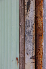 Details of parts of an old shed, weathered wooden plank, rusty metal and corrugated iron sheet