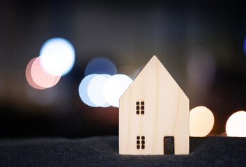Obraz na płótnie Canvas House or home wood model for family happy concept with bokeh light from modern downtown city in business movement background