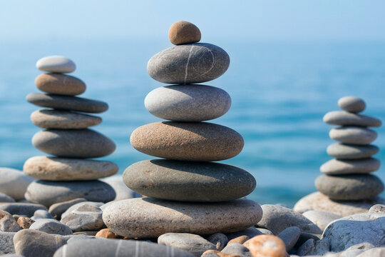 Pyramids of sea pebbles on the beach against the sea on a Sunny day