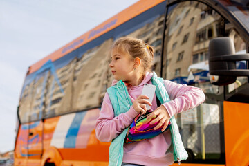 
little girl next to the bus