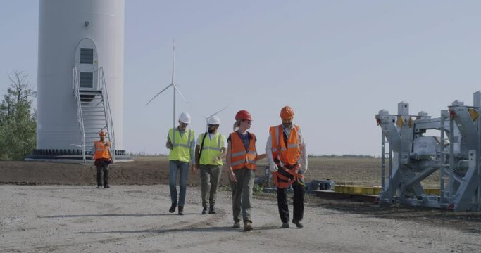 Group of workers walking away from wind turbine