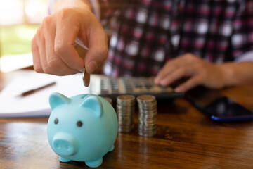 Businessman Holding Coins Putting a Coin into Piggy Bank,concept Saving Money for Finance Accounting.