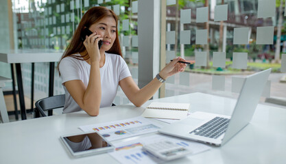 Financial Businesswomen analyze the graph of the company's performance to create profits and...