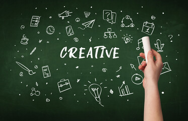 Hand drawing CREATIVE inscription with white chalk on blackboard, education concept