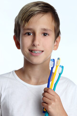 Portrait of a boy holding a tooth brush over white background