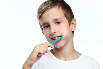 boy cleaning his teeth over white background