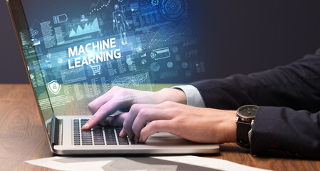 Obraz na płótnie Canvas Businessman working on laptop with MACHINE LEARNING inscription, cyber technology concept