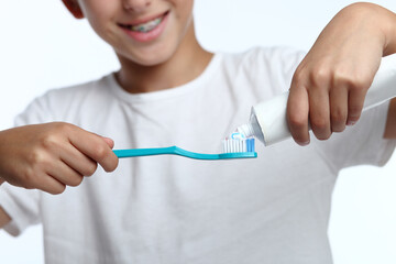 Happy kid taking toothpaste and preparing to brush his teeth with toothbrush