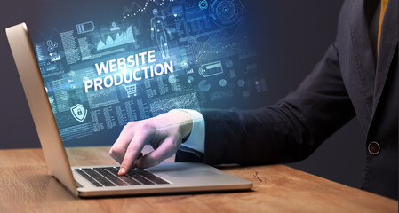 Businessman working on laptop with WEBSITE PRODUCTION inscription, cyber technology concept