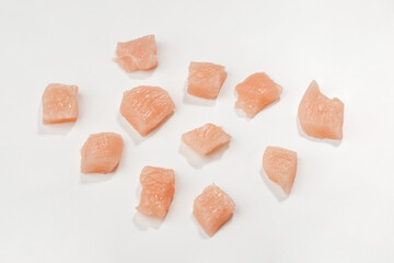 Chicken fillet diced into small cubes on white background