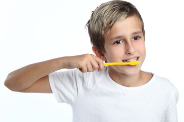 kid smiles while brushing his teeth