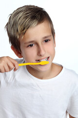 kid smiles while brushing his teeth