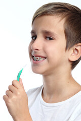 Boy with braces smiling while brushing your teeth
