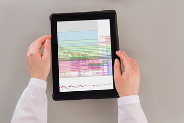 Business woman working with trading graphs on tablet pc. Top view of businesswoman hands using digital tablet with diagrams and graphs on screen.