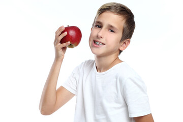 Young boy eating a red apple on a white background