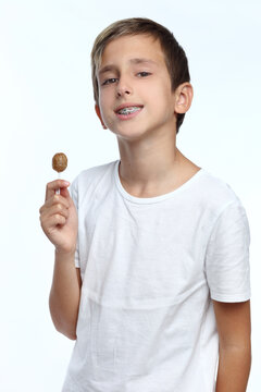 Portrait of beautiful joyful boy with lollipop isolated on white background